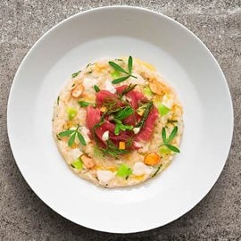 Rižota z mandljevim mlekom, kandirano limono, karpačem rdeče tune in osočnikom